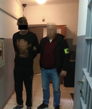 policjant doprowadza zatrzymanego