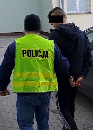 policjant doprowadza zatrzymanego 20-latka