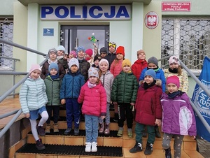 zdjęcie grupowe dzieci przed budynkiem komendy