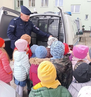 policjant pokazuje dzieciom radiowóz