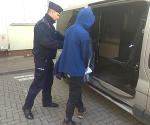 policjant doprowadza zatrzymanego