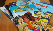 "komiksy leżące na stole"