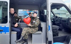 uczniowie siedzący w radiowozie.