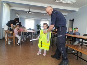 dziecko przymierza kamizelkę policyjną