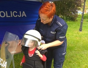 policjantka ubiera dziecko w umundurowanie