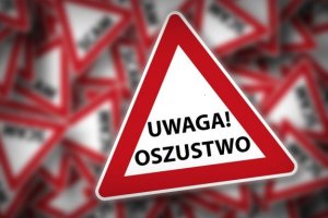 biały trójkąt z czerwonym obramowaniem, w środku napis Uwaga Oszustwo. W tle niewyraźne trójkąty