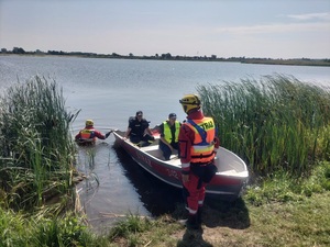 policjanci i strażacy na brzegu podczas przygotowań do wypłynięcia