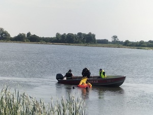 policjanci i strażacy na łodzi w trakcie ćwiczeń
