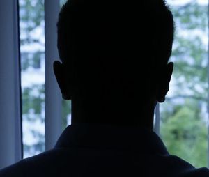 sylwetka postaci na tle okna