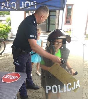 policjant pomaga przymierzyć elementy wyposażenia.j