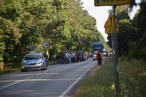 policjanci jadą w radiowozie przed pielgrzymką