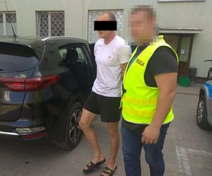 policjant doprowadza zatrzymanego