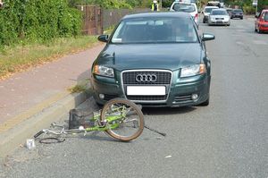uszkodzony samochód i leżący przed nim rower