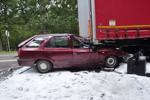 uszkodzony samochód osobowy i fragment naczepy ciężarówki