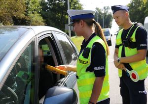 patrol ruchu drogowego. Policjantka sprawdza trzeźwość kierującego