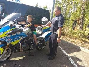 policjant przy motocyklu z dzieckiem.