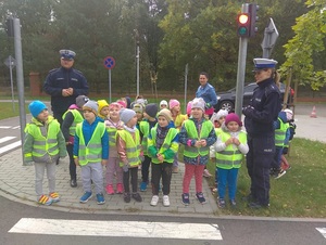 dzieci z policjantami przed przejściem dla pieszych