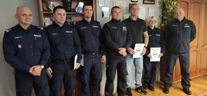 wspólne zdjęcie komendanta, policjantów i ich przełożonych