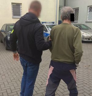 policjant prowadzi zatrzymanego