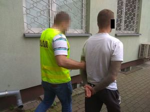 policjant prowadzi zatrzymanego 30-latka
