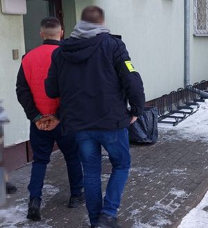 policjant prowadzi zatrzymanego mężczyznę