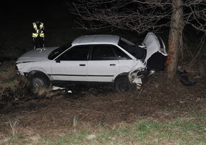 uszkodzony samochód stojący obok drzewa