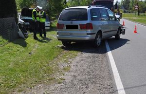 miejsce wypadku. Policjanci wykonują czynności przy uszkodzonym samochodzie