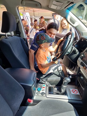 dziecko siedzi za kierownicą radiowozu.