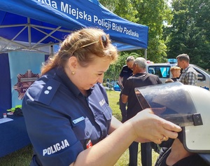 policjantka pomaga przymierzyć dziecku elementy umundurowania