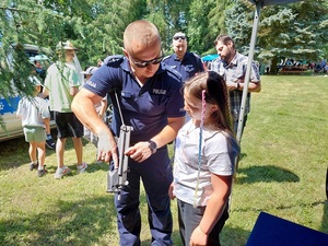 policjant pokazuje dziecku broń.