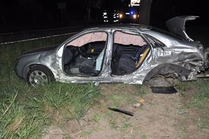 uszkodzony samochód. W tle strażacy