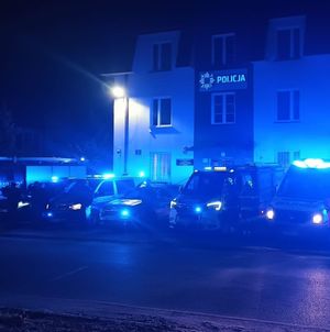 policjanci i funkcjonariusze innych służb oddają honor przed budynkiem komendy