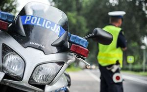 policjant ruchu drogowego stojący przy motocyklu