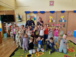 zdjęcie grupowe policjanta z dziećmi i ich opiekunem