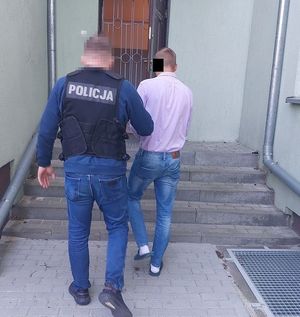 policjant w ubraniu cywilnym prowadzi zatrzymanego