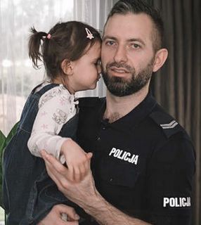 policjant trzymający córeczkę na rękach