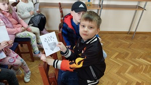 dziecko pokazuje własnoręcznie wykonaną odbitkę swojej doni