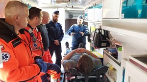 policjanci i ratownicy w karetce