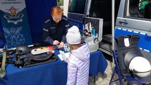 policjantka wspólnie z dzieckiem zabezpiecza odbitki linii papilarnych
