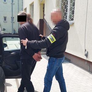 policjant prowadzi zatrzymanego