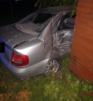 fragment uszkodzonego samochodu i ogrodzenie w które uszkodził