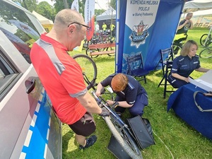 policjanci w namiocie. Policjantka znakuje rower