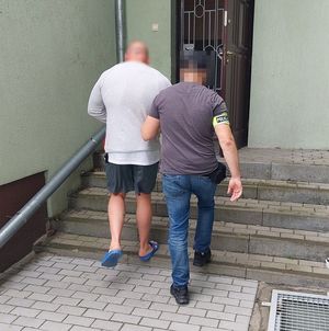 policjant prowadzi zatrzymanego