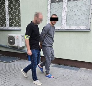 policjant prowadzi zatrzymanego