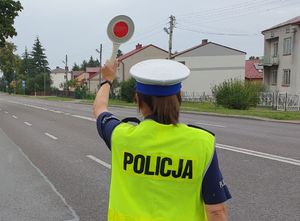 policjantka z tarczą do zatrzymywania pojazdów