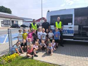 policjanci z dziećmi przy radiowozie