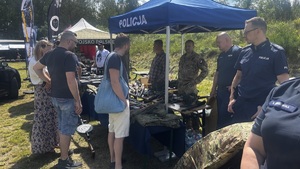 Policjanci i osoby zainteresowane przy stoisku policyjnym