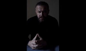 czarno--białe zdjęcie siedzącego mężczyzny