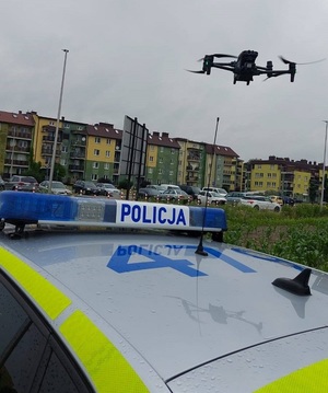 dron wiszący nad radiowozem policyjnym