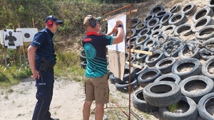policjant i sędzia przy tarczy strzelniczej
